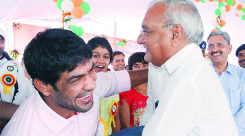 Hooda tries his hands at wrestling with Commonwealth Games gold medallist Sushil Kumar at Sonepat on Friday. Source: Express  Photo