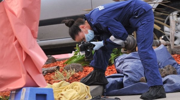 A forensic officer documents objects including a blanket at the scene of a fatal shooting at Endeavour Hills Police Station in Melbourne, Wednesday, Sept. 24, 2014. (Source: AP)