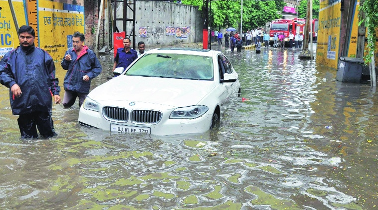 Fire brigade personnel drag a car  stuck in the waterlogged Mithakhali underbridge in Ahmedabad. (Source: Express photo by Javed Raja)