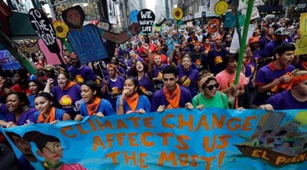 Young people carry banners and signs as they demonstrate in a climate change march Sunday, Sept. 21, 2014, in New York. (Source: AP)