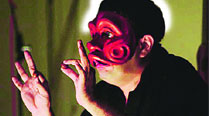 Deepal Doshi enacting a scene wearing a mask