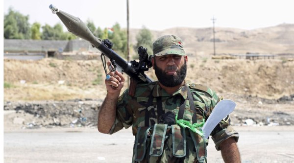 A Shiite militiaman stands guard in Amirli, where 15,000 Shiite Turkmens were stranded in the farming community surrounded by militants since mid-July, 105 miles (170 kilometers) north of Baghdad, Iraq. (Source: AP)