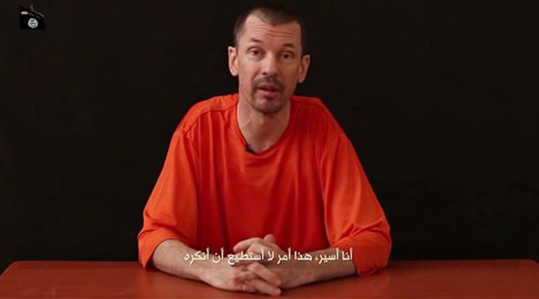 In this still image taken from an undated video published on the Internet by Al-Furqan, the media arm of the Islamic State group militants, captive British journalist John Cantlie speaks into the camera on the first of what he says will be a series of lecture-like "programs" in which he says he will reveal "the truth" about the Islamic State group. The Arabic subtitle reads "I am a prisoner and that is something I will not deny." (Source: AP)