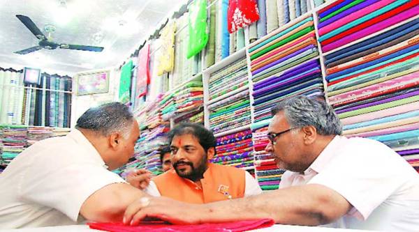 Gopal Kanda in conversation with voters at a saree shop in Sirsa city during his campaign. ( Source: Express photo by Gajendra yadav )