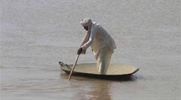 A Pakistani villager wades through floodwaters in district Shorkot near Jhang, Pakistan. (Source: AP)