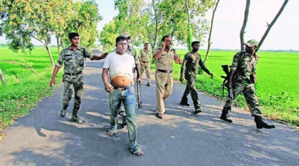 Police and RAF personnel arrest a TMC activist for allegedly throwing crude bombs at a bus carrying BJP supporters in Birbhum, Friday. The BJP supporters were on their way to hold a protest at a police station. ( Source: PTI )
