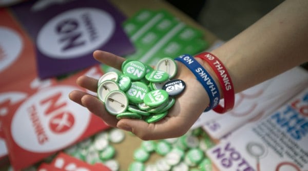 "No Thanks" badges, wrist bands and stickers are offered to supporters as Member of Parliament and Shadow Secretary of State for International Development, Jim Murphy, speaks in support of the Union on the final day of his 100 Streets in 100 Days Better Together tour, in Sauchiehall Street, Glasgow, Scotland. (Source: AP)