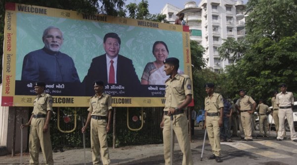 Indian policemen stand next to a welcome hoarding being erected ahead of an anticipated visit by Chinese President Xi Jinping as they review security arrangements in Ahmadabad, India, Monday, Sept. 15, 2014. (Source: AP)