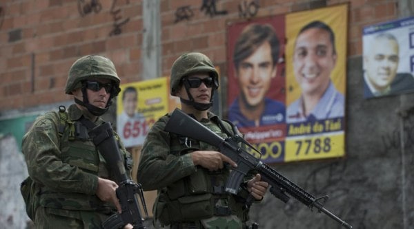 Brazilian soldiers guard the Mare Complex slum ahead of elections, in Rio de Janeiro, Brazil, Saturday, Oct. 4, 2014. Brazil is preparing for general elections to be held Sunday, Oct. 5.(Source: AP)
