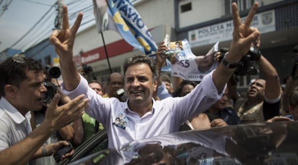 FILE - In this Sept. 30, 2014 file photo, Aecio Neves, presidential candidate of the Brazilian Social Democracy Party, PSDB, flashes a victory sign as he campaigns at the "Mercadao de Madureira," or Madureira Market in Rio de Janeiro, Brazil. Brazil will hold general elections on Oct. 5. (Source: AP)