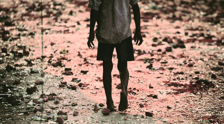 BRICK LANE: A Trilokpuri boy walks over broken bricks and shards of glass, remains of Saturday’s rioting.(Express photo by Oinam Anand)