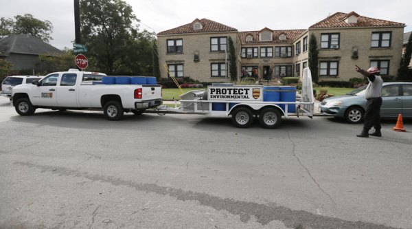 Disposal barrels are stationed outside the apartment of a healthcare worker, who treated Ebola patient Thomas Eric Duncan and tested positive for the disease, Monday, Oct. 13, 2014, in Dallas. (Source: AP)