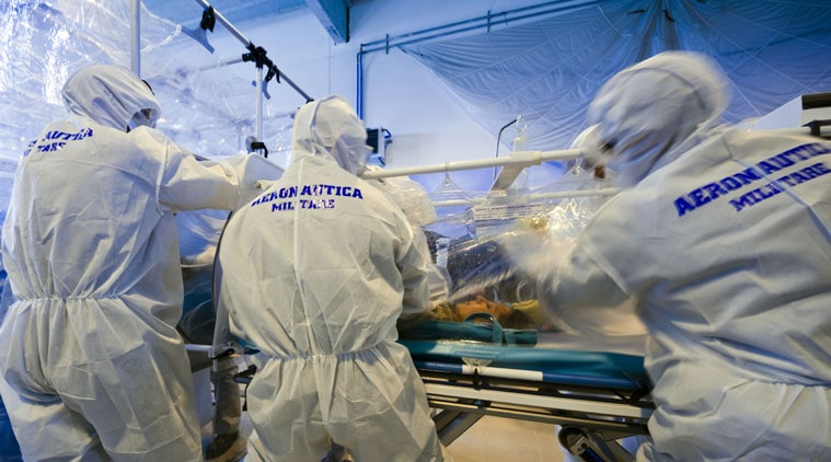 Participants into a course to learn how to transport and handle contagious patients use an 'Aircraft Transit Isolator' to carry a colleague during a simulation at the military airport of Pratica di Mare, Rome. (AP Photo)