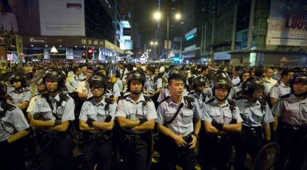 Riot police stand guard at the occupied area in the Mong Kok district of Hong Kong, early Monday, Oct. 20, 2014. Three weeks ago, students at a rally stormed a fenced-off courtyard outside Hong Kong's government headquarters, triggering unprecedented mass protests for greater democracy in the semiautonomous Chinese city. (Source: AP)