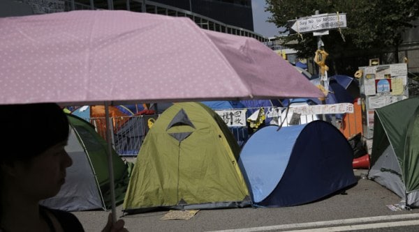 A woman walks past some tents in an occupied area by pro-democracy protesters outside government headquarters in Hong Kong's Admiralty district Monday, Oct. 20, 2014. (Source: AP)