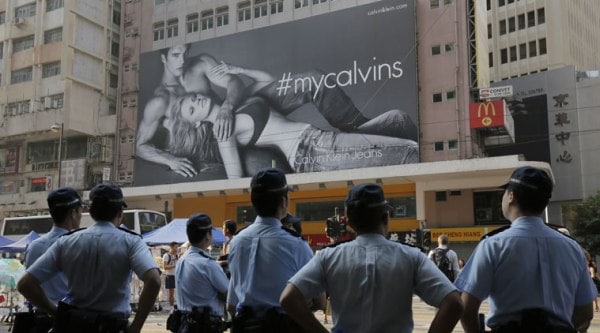 Police officers stand guard after they removed barricades that protesters have set up to block off main roads in Causeway Bay district in Hong Kong Tuesday, Oct. 14, 2014. (Source: AP)