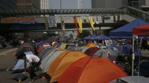 Pro-democracy protesters set up tents on a main road in an occupied area outside government headquarters in Hong Kong's Admiralty district Wednesday, Oct. 15, 2014. (Source: AP)