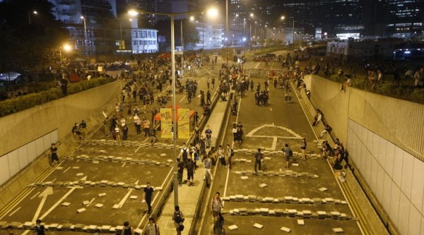 Demonstrators block the underpass with concrete slabs taken from drainage ditches at the main roads outside government headquarters in Hong Kong's Admiralty, Wednesday, Oct. 15, 2014. (Source: AP)