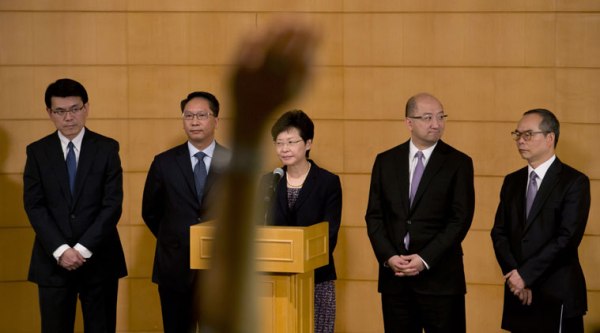 A reporter raises a hand to cast a question as Hong Kong government officials, from right, Undersecretary of the Constitutional and Mainland Affairs Bureau Lau Kong-wah, Secretary for Constitutional and Mainland Affairs Raymond Tam, Chief Secretary for Administration Carrie Lam, Secretary for Justice Rimsky Yuen and Chief Executive's Office Director Edward Yau Tang-wah attend a news conference after their talks on constitutional development with the student leaders in Hong Kong Tuesday, Oct. 21, 2014. (Source: AP)