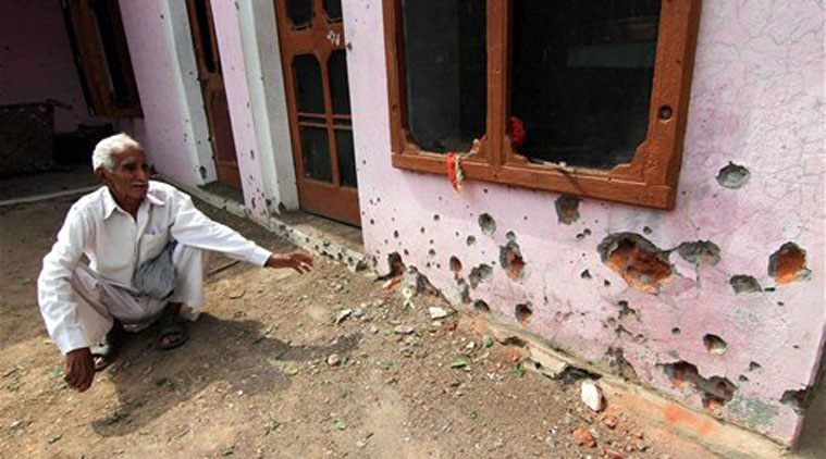  A man sits outside his house after shelling from Pakistan side damaged the walls of his residence at village Chilayari in Jammu on Wednesday. (Source: PTI)
