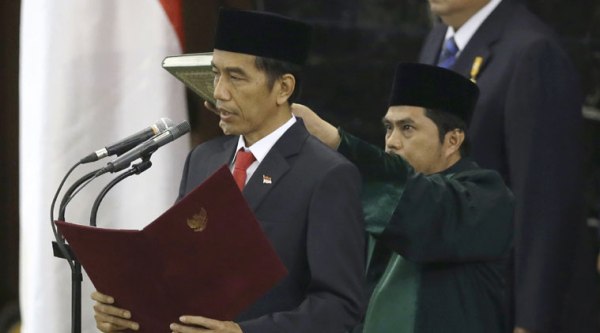 Indonesian President Joko Widodo, center, reads his oath during his inauguration ceremony as the country's seventh president at the parliament building in Jakarta, Indonesia, Monday, Oct. 20, 2014. (Source: AP)