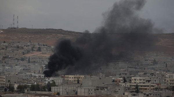 Smoke from a fire rises following a strike in Kobani, Syria, during fighting between Syrian Kurds and the militants of Islamic State group, as seen from a hilltop on the outskirts of Suruc, at the Turkey-Syria border, Sunday, Oct. 19, 2014. (Source: AP)