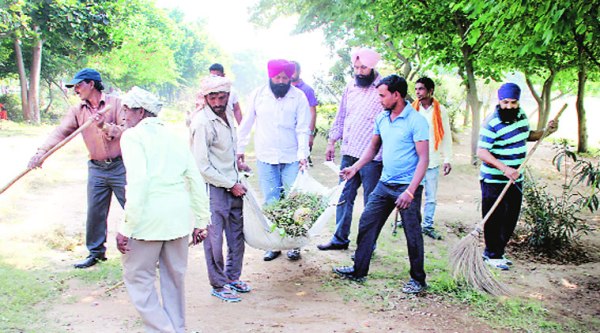 SAD councillor  Tanvir Dhaliwal with other party workers during the cleanliness drive at  Leisure Valley. (Source: Express photo by Gurmeet Singh)
