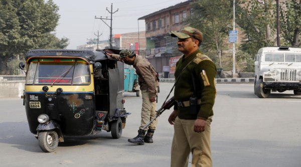 Indian policemen check passing vehicles on a street in Srinagar on Thursday. (Source: AP)