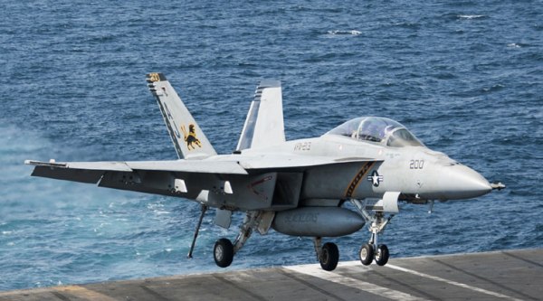 In this Tuesday, Sept. 23, 2014 photo released by the U.S. Navy, an F/A-18F Super Hornet, attached to the "Fighting Black Lions" of Strike Fighter Squadron (VFA) 213 lands aboard the aircraft carrier USS George H.W. Bush, which is supporting U.S.-led coalition airstrikes on Islamic State group and other targets in Syria and Iraq. (Source: AP)
