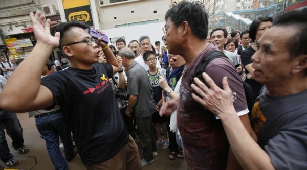 A pro-democracy student protester, left, argues with angry locals trying to remove the barricades blocking local streets in Causeway Bay, Hong Kong on Friday. (Source: AP photo)
