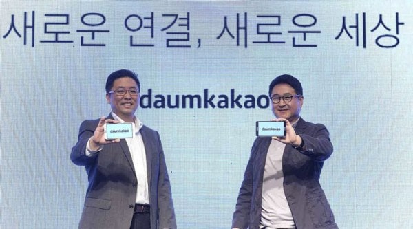 In this Oct. 1, 2014 photo released by Daum Kakao, Saehoon Choi, left, and Sirgoo Lee, the two co-CEOs of Daum Kakao, an Internet portal and app developer, show their company's new logo during a press conference in Seoul, South Korea. (Source: AP)
