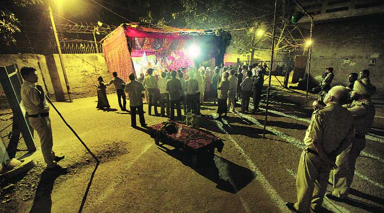 Policemen watch aarti at Mata ki chowki, the spot where a fight may have triggered Trilokpuri riots. (Source: Express photo by Ravi Kanojia)