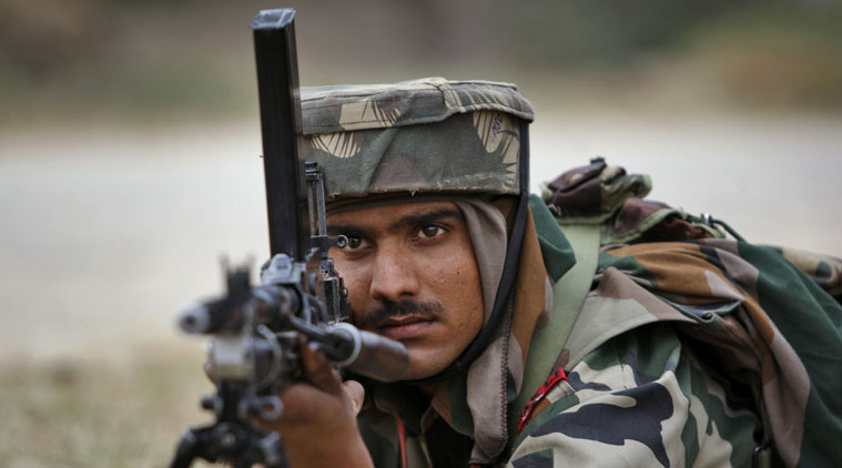 An Indian Army soldier takes position during an encounter with armed suspected militants at Pindi Khattar village in Arnia border sector, 43 kilometers (27 miles) south of Jammu, India, Thursday, Nov. 27, 2014. An army officer says some of the militants occupied an abandoned bunker in Jammu region early Thursday and fired at the soldiers in Arnia sector in the Indian portion of Kashmir. (AP Photo/Channi Anand)