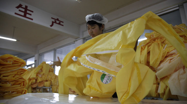 In this photo taken Thursday, Oct. 30, 2014, Chinese workers manufacture protection suits that meet the standards for use by healthcare workers treating Ebola patients at a factory of U.S. based Lakeland Industries in Anqiu city in eastern China's Shandong Province. Far from the Ebola hot zone, the sewing and gluing machines at a factory in China have been whirring more than usual to produce crucial yellow suits that protect the front-line medics more than 11,000 kilometers (7,000 miles) away in West Africa. (Source: AP)