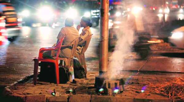Two women constables on night duty at the Bandra-Mahim junction burn ember to keep mosquitoes away as city grapples with dengue. (Source: express photo by Vasant Prabhu)