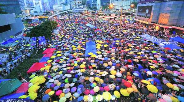 Protesters open their umbrellas, symbols of pro-democracy movement, as they mark one month since they took to the streets in Hong Kong’s financial central district .