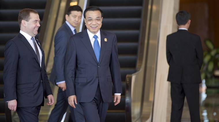Russian Prime Minister Dmitry Medvedev, left and Chinese Prime Minister Li Keqiang, center, smiles ahead of the East Asia summit plenary session at Myanmar International Convention Center in Naypyitaw, Myanmar, Thursday, Nov. 13, 2014.