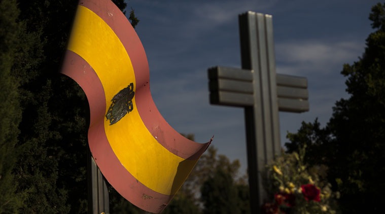 Flowers are placed on the tomb of Spanish Army Blue Division members who died during WWII, next a Spanish pre-constitutional flag during All Saints Day, a Catholic holiday to reflect on the saints and deceased relatives, Madrid, Spain.
