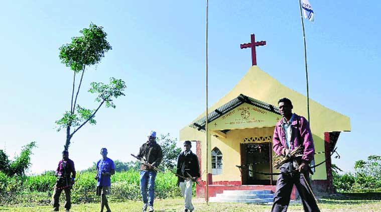 Adivasis stand guard outside a church in Assam’s Sonitpur district, where people have taken refuge to escape the militants. (Source: Express photo Dasarath Deka)