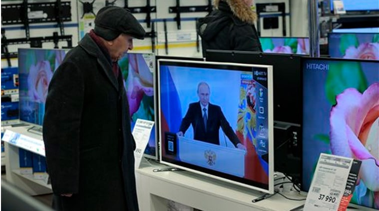 Customers look at TV sets with Russian President Vladimir Putin, at a shop in Moscow, Russia, on Thursday, Dec. 4, 2014, during his annual state of the nation address in the Kremlin.(Source:AP)