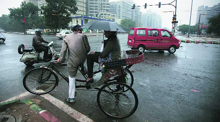 rare sight: A drenched rickshaw-puller looks for cover near Connaught Place on Sunday. Cycle-rickshaws are not allowed to ply in the area. (Source: Express photo by Amit Mehra)