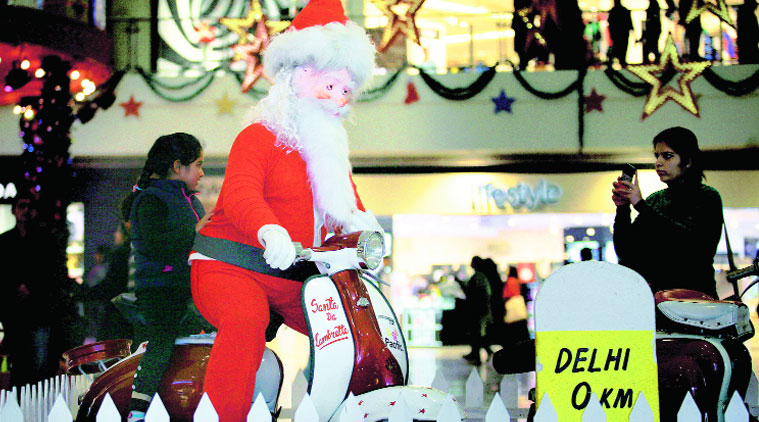Santa Claus gives a girl a scooter ride in Ghaziabad’s Pacific Mall on Tuesday.(Source: Express photo by Praveen Khanna)