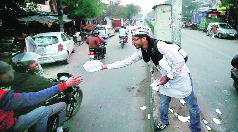 An AAP volunteer campaigns on a busy road in the capital. (Source: Express Photo by Praveen Khanna)