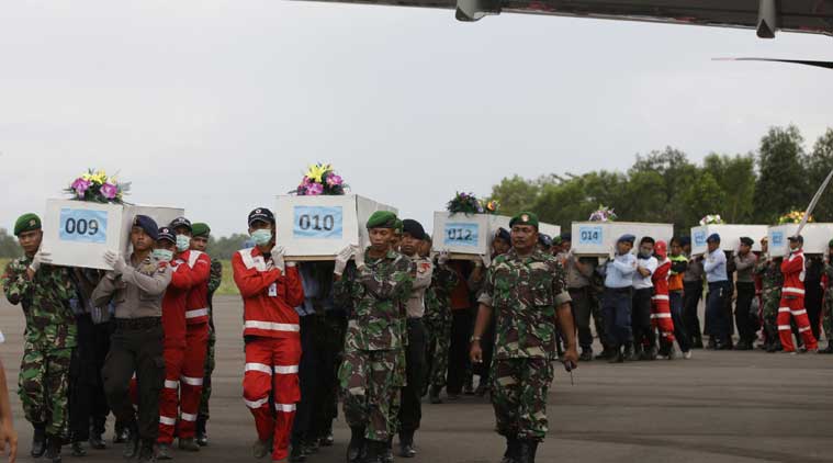 Members of the National Search And Rescue Agency carry coffins containing the body of the victims aboard AirAsia Flight 8501 to transfer to Surabaya at the airport in Pangkalan Bun, Indonesia. (Source: AP photo)