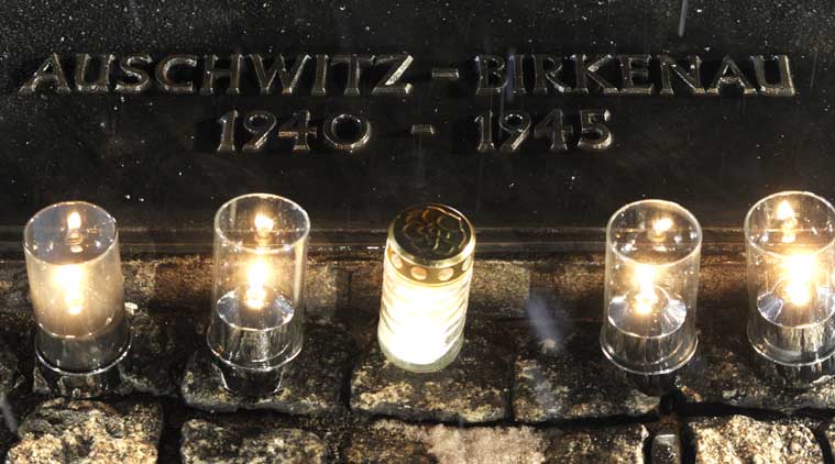 Candles burn by a memorial plaque at the Birkenau Nazi death camp in Oswiecim, Poland, Tuesday, Jan. 27, 2015, after the official remembrance ceremony. About 300 survivors gathered with leaders from around the world to remember the 1.1 million people killed at Auschwitz-Birkenau and the millions of others killed in the Holocaust.(AP Photo/Alik Keplicz)
