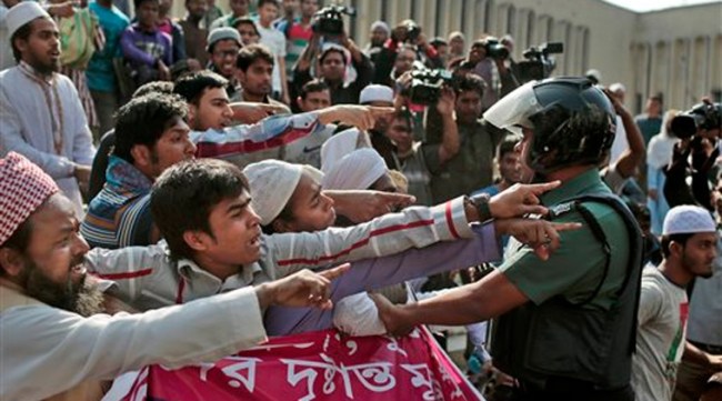 A Bangladeshi policeman tries to stop clashes between protesters and ruling Awami League party activists outside the Bangladesh National Mosque during a protest in Dhaka, Bangladesh, Thursday, Jan. 15, 2015. (AP Photo)