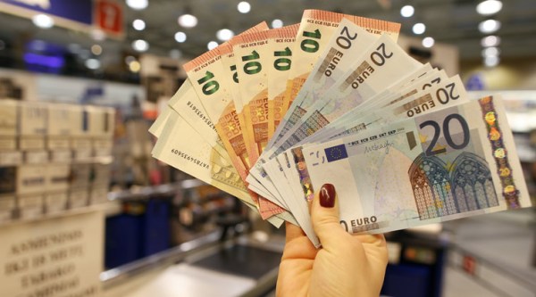 Euro bills are displayed by a salesperson in a shop in Vilnius, Lithuania. (Source: AP)
