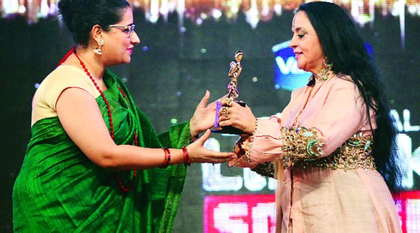Kausar Munir receives her trophy from Ila Arun