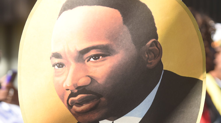 onathan Smith carries a picture of Rev. Martin Luther King Jr. during a parade to honor King, Monday, Jan. 19, 2015, in Chattanooga, Tenn. (AP Photo/Chattanooga Times Free Press, Angela Lewis Foster)