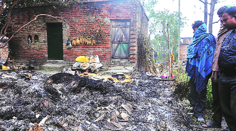 Villagers of Azizpur look at the remains of houses torched in the attack.(Express photo by Prashant Ravi)